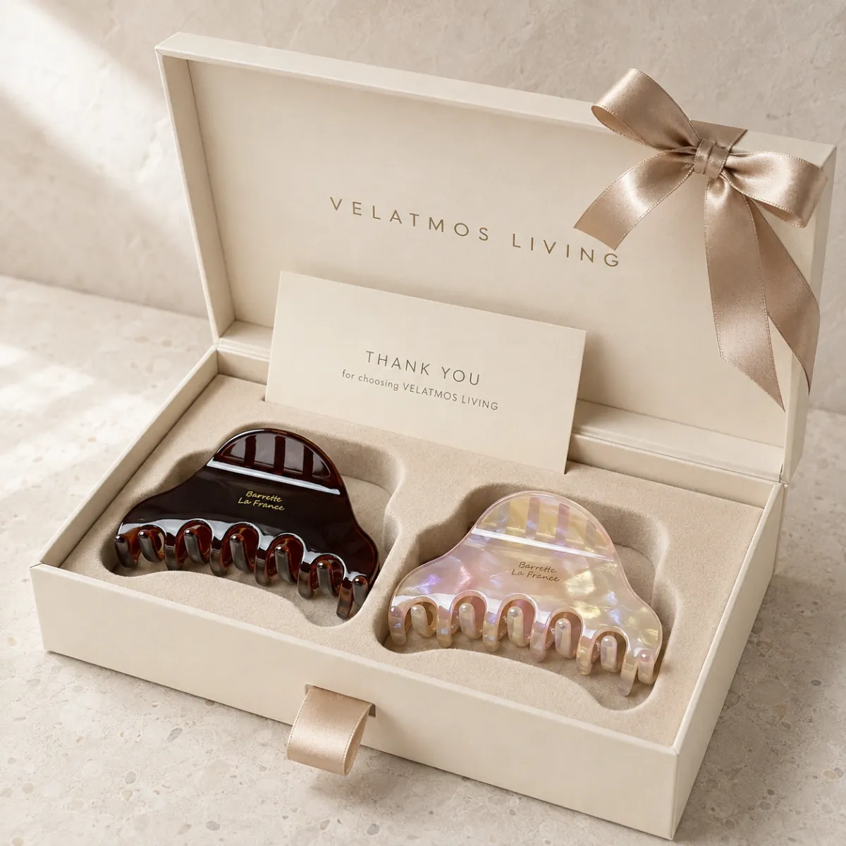 Caramel Amber and Moonlit Pearl Aurelia Arc acetate claw clips in a fitted warm ivory gift box